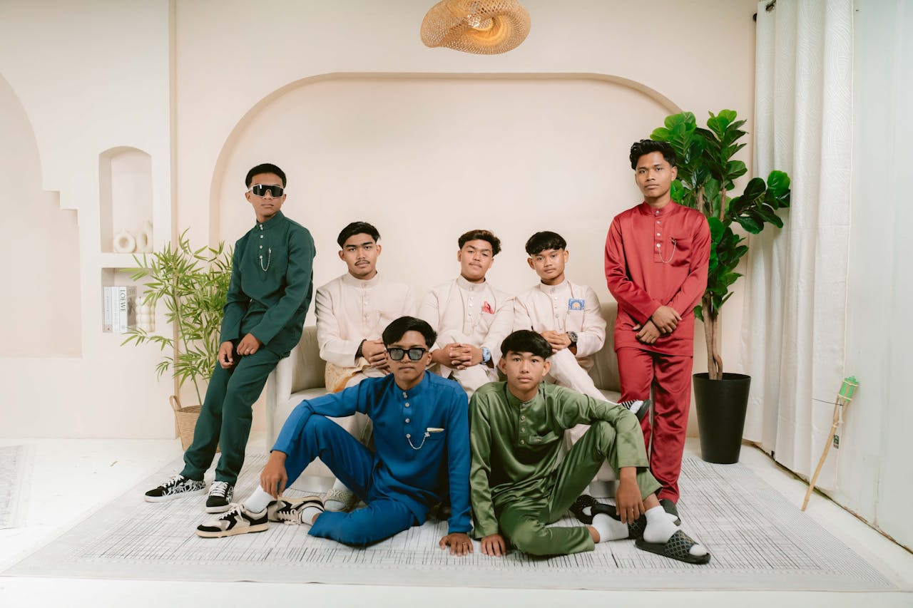 gallery-03 Group of young men posing indoors in colorful traditional outfits, showcasing style and unity.